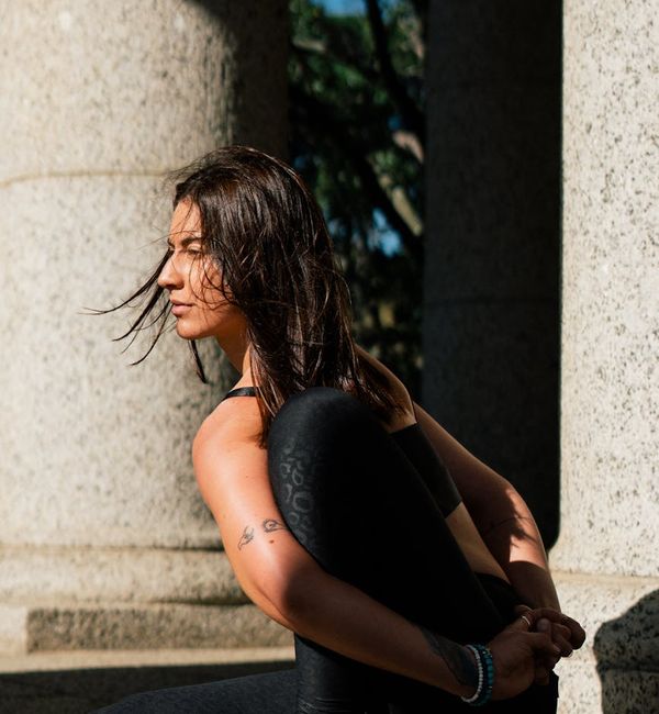 Person sitting in a calm cross-legged yoga pose with golden glow accents.