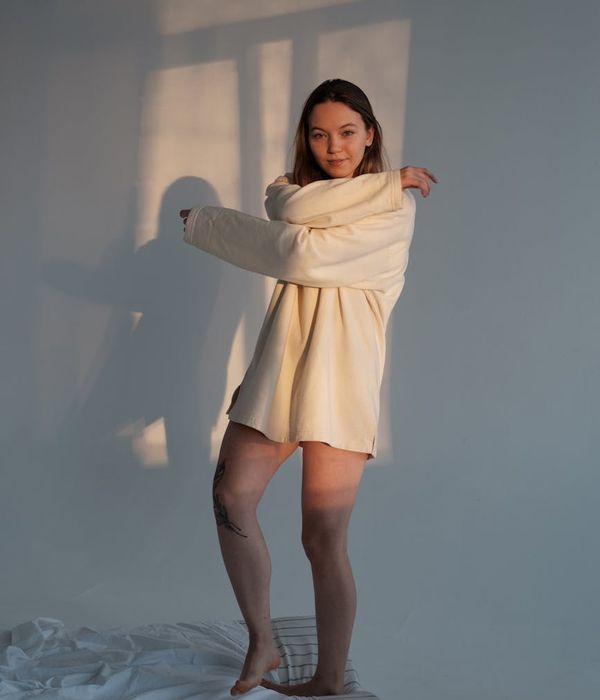 Woman in a graceful morning yoga pose, bathed in soft lavender light.
